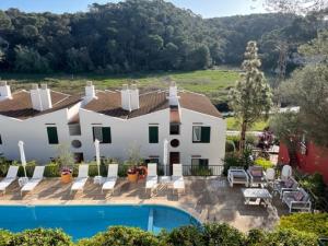 a large white house with a swimming pool at The Desmais in Cala Galdana