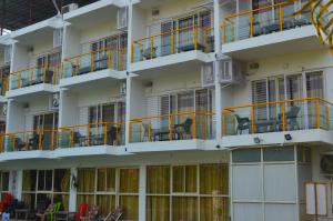 un edificio de apartamentos con mesas y balcones naranjas en Nilaya Nest Away, en Alibaug