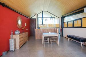 a dining room with a table and a red wall at Villa Bima II in Nusa Dua