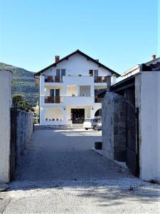 a large white building with a parking lot at Herceg Vila in Trebinje