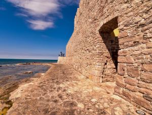 een oude stenen muur naast het strand bij Guest House Torci 18 in Novigrad Istria
