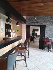 - un bar dans un restaurant avec des chaises et une table dans l'établissement Le Relax, à Aurillac