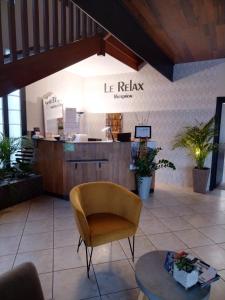 une salle d'attente avec une chaise et une table dans l'établissement Le Relax, à Aurillac