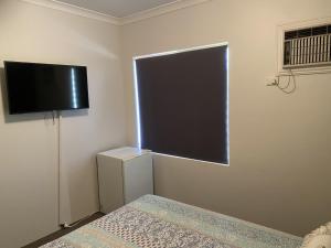 um quarto com uma janela e uma televisão na parede em The Piccadilly Hotel em Kalgoorlie