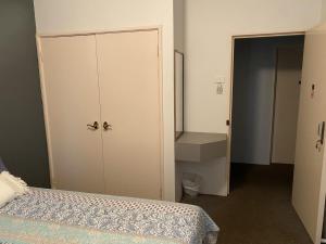 um quarto com uma cama, um armário e um armário em The Piccadilly Hotel em Kalgoorlie