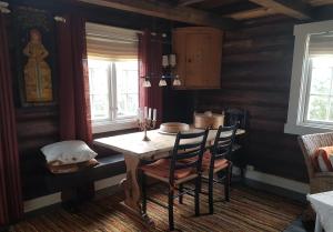 uma sala de jantar com uma mesa de madeira e cadeiras em Fredelig plass for rekreasjon em Krøderen