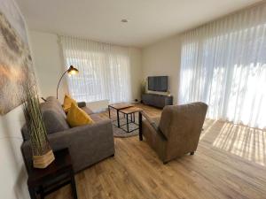 ein Wohnzimmer mit einem Sofa und einem TV in der Unterkunft Kapitänshaus Lassen - Zimmer Atlantis in Westerland