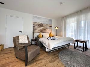 - une chambre avec un lit et une chaise dans l'établissement Kapitaenshaus-Lassen-Zimmer-Atlantis, à Westerland
