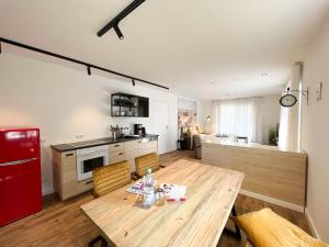 eine Küche mit einem Holztisch und einem roten Kühlschrank in der Unterkunft Kapitänshaus Lassen - Zimmer Atlantis in Westerland