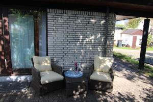 2 Stühle und ein Tisch auf der Terrasse in der Unterkunft Kapitänshaus Lassen - Zimmer Atlantis in Westerland