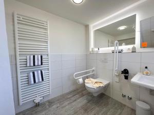 Kapitaenshaus-Lassen-Zimmer-Atlantis في فيسترلاند: حمام مزود بمرحاض ومغسلة ومرآة +7 صور