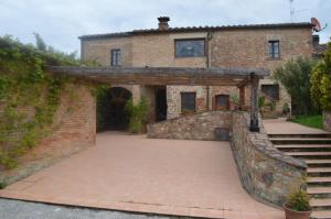 - une vue extérieure sur une maison dotée d'un mur en briques dans l'établissement Il casale di Sandra, à Chiusi