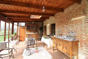 eine Terrasse mit Tischen und Stühlen und einer Ziegelwand in der Unterkunft Il casale di Sandra in Chiusi
