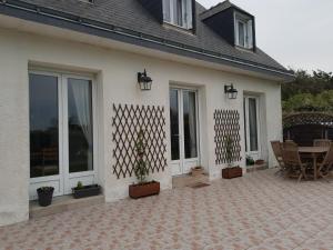 eine Terrasse eines Hauses mit einem Tisch und Stühlen in der Unterkunft Les Avocettes in Piriac-sur-Mer