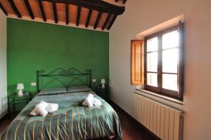 a green bedroom with a bed with two towels on it at Il casale di Sandra in Chiusi