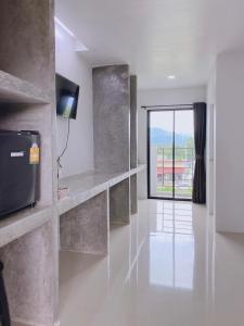 een woonkamer met een groot raam en een witte vloer bij Momda Resort @Ranong in Ranong