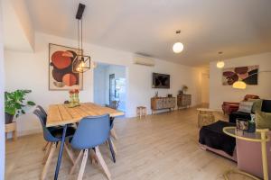a living room with a table and blue chairs at ViLLA MI SOL in Torrevieja