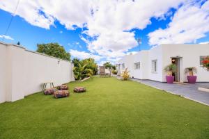 a large yard with white buildings and green grass at ViLLA MI SOL in Torrevieja
