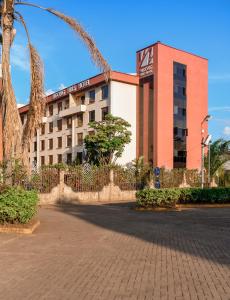 a hotel building with a palm tree in front of it at Ngong Hills Hotel in Nairobi