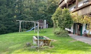 a playground in a yard next to a house at Gartenwohnung im Gut Sonnenwald in Schöllnach +6 photos