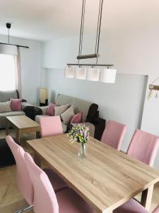 莫納奇爾的住宿－AT VISTA GRANADA，一间带桌子和粉红色椅子的用餐室