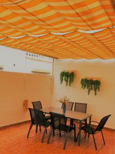 una sala da pranzo con tavolo e sedie sotto un soffitto in legno di AT VISTA GRANADA a Monachil
