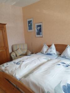 een slaapkamer met een groot wit bed en een stoel bij Ferienwohnung Thönnes in Müden
