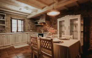 uma cozinha com mesa e cadeiras num quarto em Casas Alexandre em Pontevedra
