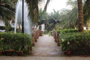 een loopbrug naar een fontein in een resort bij Nath's Residency in Puri