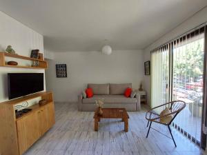 Una sala de estar con un sofá y un televisor. en UMBRAL, en San Martín de los Andes