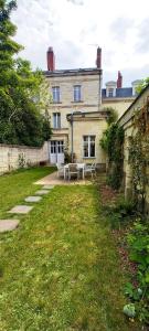 a house with a table and chairs in the yard at HISTOIRE DE LOIRE - La Maison in Saumur
