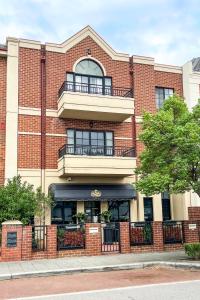 a large red brick building with a balcony at Ganesha Wellness Spa in Perth