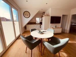 a kitchen and dining room with a table and chairs at Ferienwohnungen MEERAUSZEIT Norddeich in Norddeich