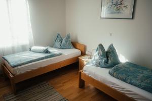 HartmannsdorfにあるGästehaus Jeindlの青い枕が付いたベッド2台が備わる客室です。