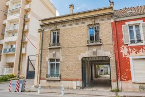 un ancien bâtiment en briques avec une porte dans une rue dans l'établissement MOULINS - Maison cosy au cœur de Reims, à Reims