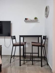 een zwarte tafel met twee stoelen en een tv bij דירת זוּגַג מפנקת עם מרפסת משגעת ונוף למפרץ. in Eilat