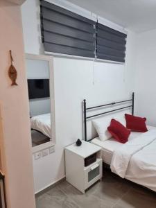 een slaapkamer met 2 bedden en een spiegel bij דירת זוּגַג מפנקת עם מרפסת משגעת ונוף למפרץ. in Eilat