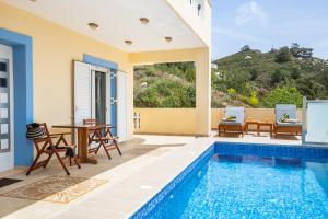 a villa with a swimming pool and a table and chairs at Karpathos View Villa in Karpathos