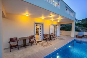a patio with a table and chairs and a swimming pool at Karpathos View Villa in Karpathos