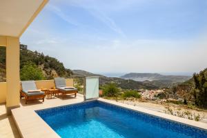 a villa with a swimming pool and a table and chairs at Karpathos View Villa in Karpathos