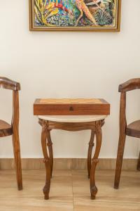 a wooden table with two chairs and a painting at Karpathos View Villa in Karpathos