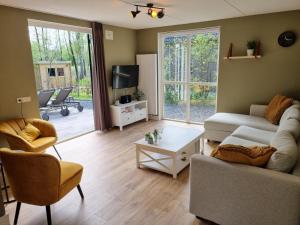 EwijkにあるFamily home, large garden, playground kids, firepit, terraces, sleeps max 7 and 1 babycot, kids playroom insideのソファとテレビのあるリビングルーム