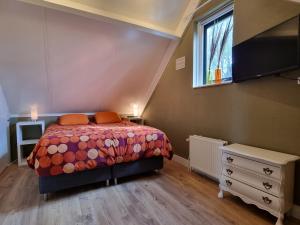 a bedroom with a bed and a dresser and a window at Family home, large garden, playground kids, firepit, terraces, sleeps max 7 and 1 babycot, kids playroom inside in Ewijk
