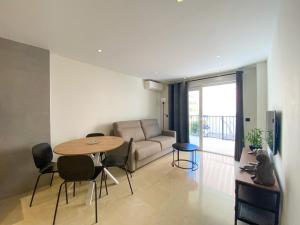 un soggiorno con divano, tavolo e sedie di El Piso - Los Boliches Full Renovated Apartment a Fuengirola
