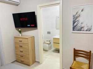 a bathroom with a toilet and a tv on the wall at Casa Vacanze Simeri Mare in Simeri Mare +19 photos