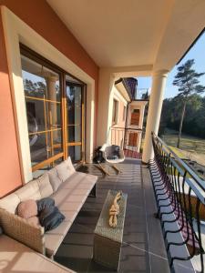 salon z kanapą i stołem na balkonie w obiekcie PRZYTULNY APARTAMENT Z KOMINKIEM PRZY JEZIORZE w Bornem-Sulinowie
