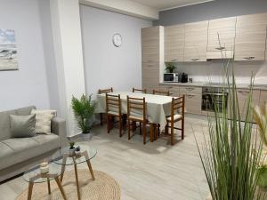 una cucina e un soggiorno con tavolo e sedie di Appartamento nuovo super accessoriato sul mare a Simeri Mare