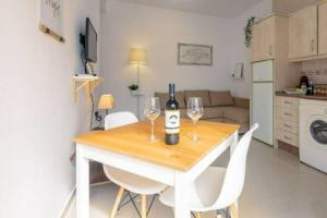 a table with two wine glasses and a bottle of wine at Apartamento El Sherezade 2 Línea Playa, in Fuengirola