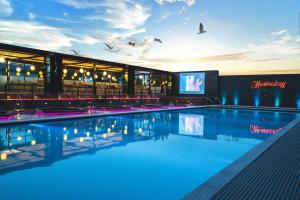 a swimming pool in front of a building with a television at Marinabay Sokcho in Sokcho