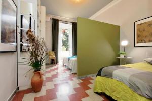 羅馬的住宿－Montesanto apartment – near the Vatican，一间卧室设有两张床和一个植物花瓶